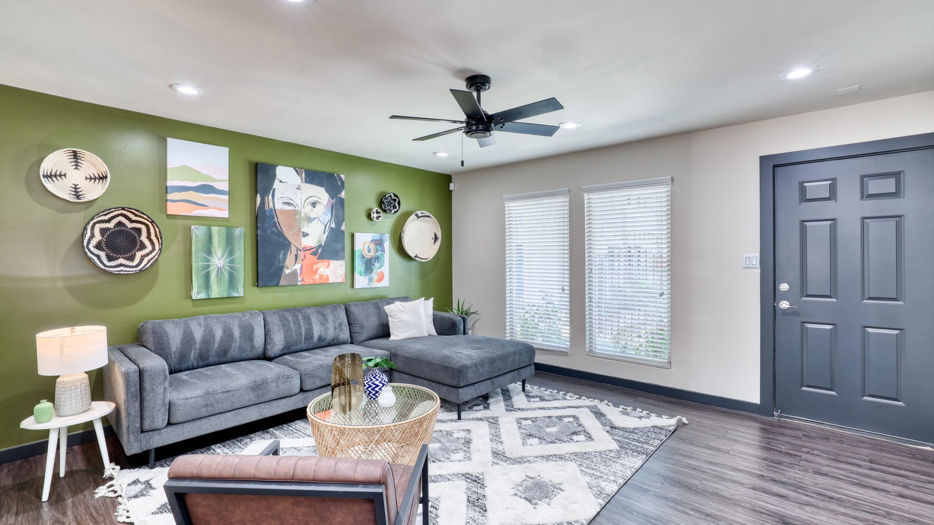 a living room with green walls and a ceiling fan at The  Palmer