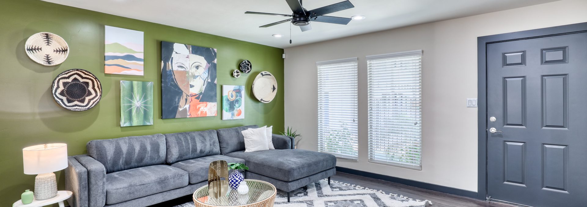 a living room with green walls and a ceiling fan at The  Palmer
